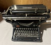 Front view of the antique Underwood typewriter showing keyboard, keys, and paper roller.