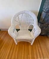 Front view of vintage white wicker chair showing woven diamond and lattice pattern on backrest and woven seat.