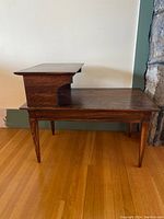 Side view of the vintage mid-century step table showing the two-tier stepped design and tapered legs.