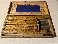 Photo of the full open wooden box with all alphabet and number stamps arranged inside showing the complete kit layout.