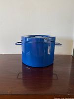Front view of vintage cobalt blue Copco enameled steel Dutch oven pot, showing the pot body and lid with visible chip on the lid.