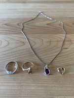 All jewelry items laid out on wood surface