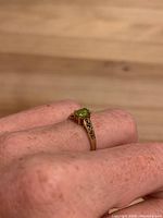 Ring worn on finger showing profile and gemstone color