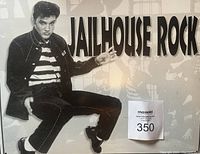 Metal sign with black-and-white Elvis Presley in dance pose and bold 'JAILHOUSE ROCK' text.