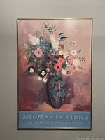 Photo of the framed poster showing Odilon Redon's Bouquet of Flowers with a mix of colorful flowers in a blue vase on a pinkish background.