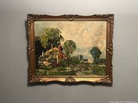 Framed rural landscape oil painting showing cottage and greenery with figures in foreground, wall-mounted