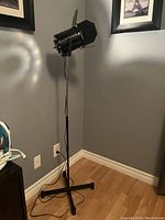Full view of the black stage light floor lamp standing on a tripod base with visible power cord.