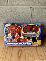 Photo of the front packaging showing the two red joysticks and light gun controllers inside blister pack with Power Player branding and graphics.