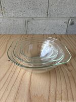 Stack of three clear glass Pyrex mixing bowls nested together.