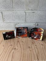 Overview of three Harley-Davidson motorcycle models in original packaging showing wear.