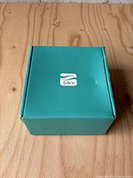 Closed turquoise box with Silk'n logo on top, showing original packaging of the device.