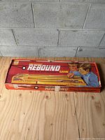 Original red box with game name, graphics of children playing, and IDEAL logo showing wear and corner damage.