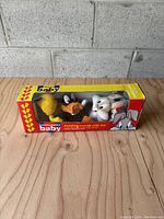 Front view of the vintage Looney Tunes baby holding hands crib toy in original box showing Tweety Bird, Daffy Duck, and Bugs Bunny.
