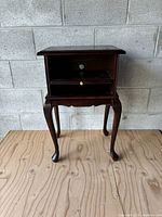 Front view of the wooden Bombay telephone table showing drawer, open shelf and leg design