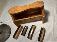 Handmade wooden shoe shine box with 4 vintage brushes arranged in front