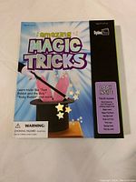 Front cover of the instruction book titled 'Amazing Magic Tricks' with details about the magic tricks and age suitability