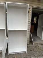 Full view of white IKEA Billy shelving unit in vertical position showing main shelving structure with two fixed shelves and space for adjustable shelves.