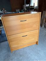Front angle view of the beech finish IKEA filing cabinet showing two drawers and key lock