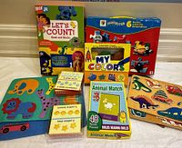 All items arranged showing puzzles, books, and boxes with bright colorful graphics and animal/number themes.