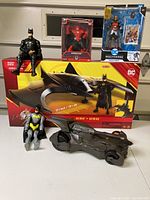Display of all items in the lot including Batwing box, Batmobile, and six figures some boxed and some loose