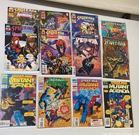 12 comic books arrayed flat showing full colorful covers featuring Spider-Man, Hulk, Venom, and team-ups with Howard the Duck.