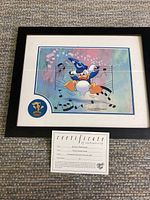 Framed limited edition print featuring Donald Duck as part of Mickey's Philharmagic with musical notes and colorful background, including Disney hologram on bottom right, and a round pin with Donald Duck conductor.