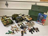 Wide shot showing entire lot of military vehicles and action figures arranged on table