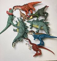 Overview of the 8 dinosaur figures placed together showing different species and colors.