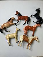Top view showing all six Breyer model horses in various poses and colors on a white background