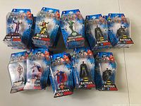 Front view of 11 mini DC superhero and villain action figures in packaging; characters include Joker, Robin, Green Lantern, Batman, Superman, and Wonder Woman.