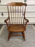 Full front view of Nichols & Stone Hitchcock style rocking chair showing curved arms, vertical spindle back, contoured wooden seat and rockers.