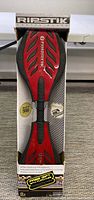 Red RipStik caster board in original box with black and red color scheme, showing top view and packaging.
