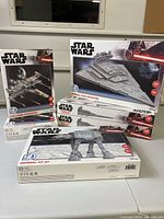 Boxed Star Wars 4D puzzles featuring Imperial Star Destroyer, T-65 X-Wing Starfighter and Imperial AT-AT models arranged on a table.