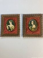 Two vintage padded cameo pictures side by side, showing quilted red fabric backing and gold ornate frames.