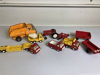 Overall view of the lot showing multiple vintage Tonka trucks in various colors with wear and paint chipping