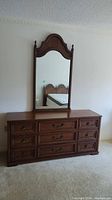 Full view of Kroehler wood veneer dresser with attached arched-top mirror in a bedroom.