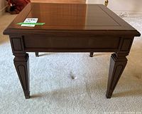 Front and side view of the dark brown square wooden table with carved leg details and polished top surface.
