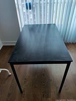 Top view of the black Ikea desk showing smooth surface and rectangular shape