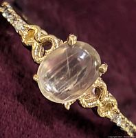 Close-up top view of ring face showing oval cabochon Zultanite and diamond accents