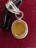 Close-up of yellow diamond pendant front showing oval faceted yellow diamond set in 14k white gold.