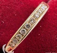 Front view of gold band showing full row of ten channel-set diamonds