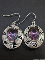 Front-facing photo showing both earrings with oval mystic topaz gems and silver filigree backs