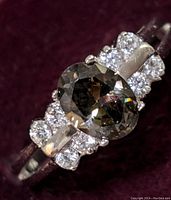 Close-up photo of the ring showing the oval mystic topaz center stone and white topaz cluster accents.