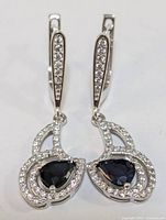 Front view of both sterling silver drop earrings with sapphire centers and CZ accents.