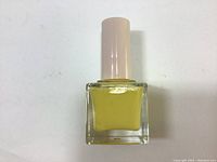 Front view of yellow nail polish bottle with light pink cap.