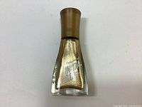 Front view showing the gold metallic nail polish bottle with plastic cap.