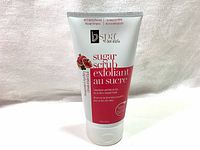 White BV Spa by Bon Vital sugar scrub exfoliant tube with product name and branding visible. The tube is standing on white fabric.