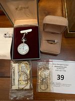 Overview of watch, chain, earrings bag, ring in box and auction tag