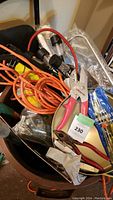 Photo of a lot with assorted tools and outdoor accessories including pliers, clamp, extension cords, and screwdrivers.