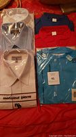 Six new men's shirts of varied colors and sizes, including dress shirts, casual shirts, and a polo shirt in original packaging.